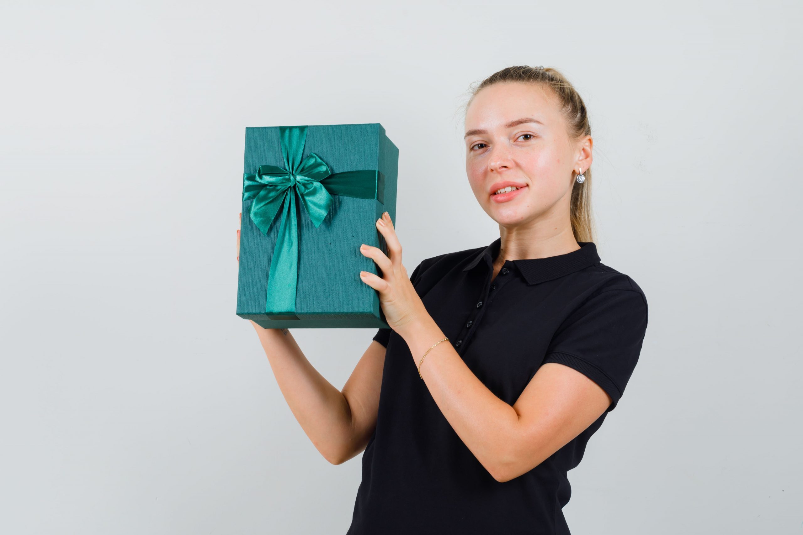 blonde-woman-black-t-shirt-holding-gift-box-smiling-looking-happy
